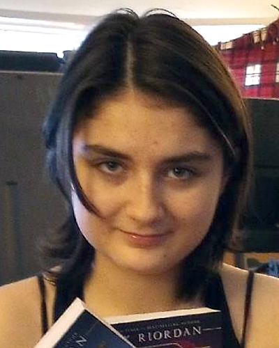 Charlotte Sterling. Missing child with brown hair and brown eyes holding a Rick Riordan novel.
